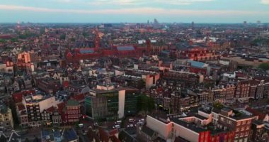 İnsansız hava aracı Amsterdam yaz şehirlerini, dar evleri, kanalları vurdu. Amsterdam, Hollanda 'nın ünlü yerlerinin hava manzarası. Göz kamaştırıcı, keskin çatıların ve modern binaların ön cephelerinin en üst görüntüsü..