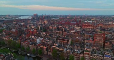 İnsansız hava aracı Amsterdam yaz şehirlerini, dar evleri, kanalları vurdu. Amsterdam, Hollanda 'nın ünlü yerlerinin hava manzarası. Göz kamaştırıcı, keskin çatıların ve modern binaların ön cephelerinin en üst görüntüsü..