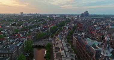 İnsansız hava aracı Amsterdam yaz şehirlerini, dar evleri, kanalları vurdu. Amsterdam, Hollanda 'nın ünlü yerlerinin hava manzarası. Göz kamaştırıcı, keskin çatıların ve modern binaların ön cephelerinin en üst görüntüsü..