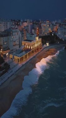 Geceleri Biarritz şehrinin inanılmaz güzel hava manzarası. Gece ışıklarıyla aydınlatılan okyanus dalgaları gece turistlerinin sahillerini yıkıyor. Fransa.
