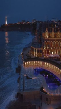 Geceleri Biarritz şehrinin inanılmaz güzel hava manzarası. Gece ışıklarıyla aydınlatılan okyanus dalgaları gece turistlerinin sahillerini yıkıyor. Fransa.