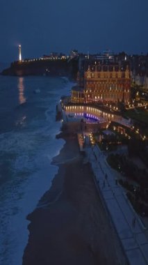 Geceleri Biarritz şehrinin inanılmaz güzel hava manzarası. Gece ışıklarıyla aydınlatılan okyanus dalgaları gece turistlerinin sahillerini yıkıyor. Fransa.