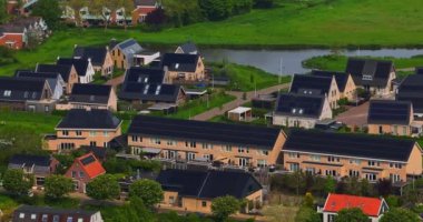 Hollanda 'nın güneşli bir gününde çatıda güneş panelleri olan evlerin havadan görünüşü. Çatıda güneş panelleri olan binaların hava görüntüleri, Hollanda, Rockanje.