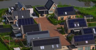 Hollanda 'nın güneşli bir gününde çatıda güneş panelleri olan evlerin havadan görünüşü. Çatıda güneş panelleri olan binaların hava görüntüleri, Hollanda, Rockanje.