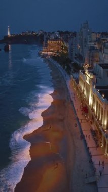 Geceleri Biarritz şehrinin inanılmaz güzel hava manzarası. Gece ışıklarıyla aydınlatılan okyanus dalgaları gece turistlerinin sahillerini yıkıyor. Fransa.