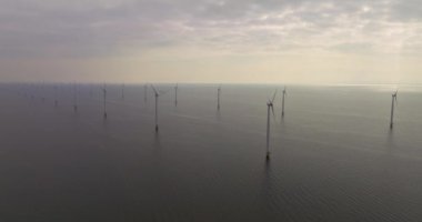 Okyanustaki açık deniz rüzgar türbinleri çiftliği. Sürdürülebilir enerji üretimi, temiz güç. Rüzgar türbinlerinin hava görüntüsü. Elektrik üreten yel değirmenleri, yeşil enerji.