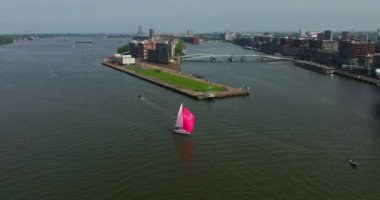 Avrupa turizm şehri Amsterdam 'ın havadan görünüşü. Gün batımında şehir merkezinde bir dron uçuyor. Hollanda 'nın en büyük ve en ünlü şehrinin çekimleri yapılıyor. Dar kanallar şehri böler.