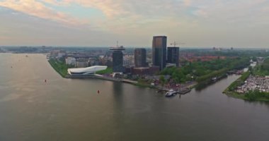 Avrupa turizm şehri Amsterdam 'ın havadan görünüşü. Gün batımında şehir merkezinde bir dron uçuyor. Hollanda 'nın en büyük ve en ünlü şehrinin çekimleri yapılıyor. Dar kanallar şehri böler.
