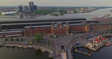 Avrupa turizm şehri Amsterdam 'ın havadan görünüşü. Gün batımında şehir merkezinde bir dron uçuyor. Hollanda 'nın en büyük ve en ünlü şehrinin çekimleri yapılıyor. Dar kanallar şehri böler.