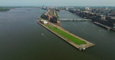 Avrupa turizm şehri Amsterdam 'ın havadan görünüşü. Gün batımında şehir merkezinde bir dron uçuyor. Hollanda 'nın en büyük ve en ünlü şehrinin çekimleri yapılıyor. Dar kanallar şehri böler.