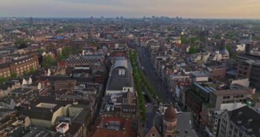 Avrupa turizm şehri Amsterdam 'ın havadan görünüşü. Gün batımında şehir merkezinde bir dron uçuyor. Hollanda 'nın en büyük ve en ünlü şehrinin çekimleri yapılıyor. Dar kanallar şehri böler.
