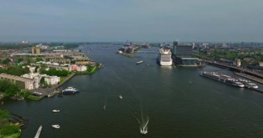 Avrupa turizm şehri Amsterdam 'ın havadan görünüşü. Gün batımında şehir merkezinde bir dron uçuyor. Hollanda 'nın en büyük ve en ünlü şehrinin çekimleri yapılıyor. Dar kanallar şehri böler.