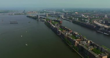Avrupa turizm şehri Amsterdam 'ın havadan görünüşü. Gün batımında şehir merkezinde bir dron uçuyor. Hollanda 'nın en büyük ve en ünlü şehrinin çekimleri yapılıyor. Dar kanallar şehri böler.