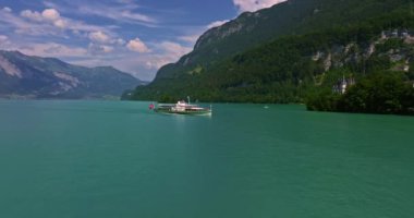 İsviçre 'de su taşımacılığı. İsviçre Gölü 'nde yol alıyorum. Interlaken Gölü 'ndeki hava manzaralı vapur gemisi. İsviçre yaz turizmi merkezi. Turkuaz mavi su. Yolcu gemisinde İsviçre bayrağı.