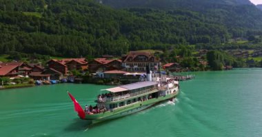 İsviçre 'de su taşımacılığı. İsviçre Gölü 'nde yol alıyorum. Interlaken Gölü 'ndeki hava manzaralı vapur gemisi. İsviçre yaz turizmi merkezi. Turkuaz mavi su. Yolcu gemisinde İsviçre bayrağı.