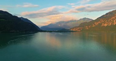 İsviçre 'de su taşımacılığı. İsviçre Gölü 'nde yol alıyorum. Interlaken Gölü 'ndeki hava manzaralı vapur gemisi. İsviçre yaz turizmi merkezi. Turkuaz mavi su. Yolcu gemisinde İsviçre bayrağı.