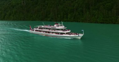 İsviçre 'de su taşımacılığı. İsviçre Gölü 'nde yol alıyorum. Interlaken Gölü 'ndeki hava manzaralı vapur gemisi. İsviçre yaz turizmi merkezi. Turkuaz mavi su. Yolcu gemisinde İsviçre bayrağı.