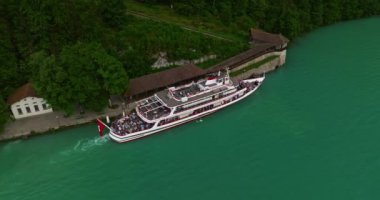İsviçre 'de su taşımacılığı. İsviçre Gölü 'nde yol alıyorum. Interlaken Gölü 'ndeki hava manzaralı vapur gemisi. İsviçre yaz turizmi merkezi. Turkuaz mavi su. Yolcu gemisinde İsviçre bayrağı.