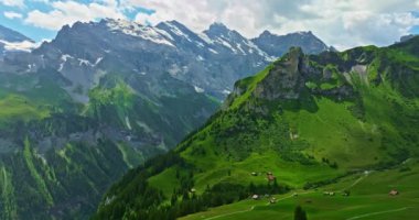 Gimmelwald 'ın küçük köyünün havadan görünüşü. Karlı dağlara karşı geleneksel evleri olan İsviçre dağ köyü. İsviçre 'deki yeşil Alp Vadisi. Yaz sabahı Alpler.