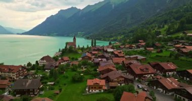 Alpler arasındaki gölün kıyısındaki geleneksel İsviçre evlerinin insansız hava aracı görüntüsü. Brienz, İsviçre. İsviçre 'nin Brienz şehrinin insansız hava aracı görüntüleri. Yazın İsviçre 'yi gezmek.