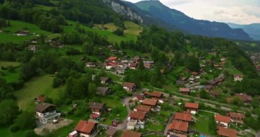 Alpler arasındaki gölün kıyısındaki geleneksel İsviçre evlerinin insansız hava aracı görüntüsü. Brienz, İsviçre. İsviçre 'nin Brienz şehrinin insansız hava aracı görüntüleri. Yazın İsviçre 'yi gezmek.