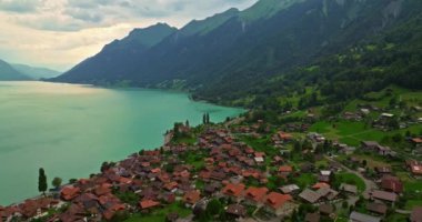Alpler arasındaki gölün kıyısındaki geleneksel İsviçre evlerinin insansız hava aracı görüntüsü. Brienz, İsviçre. İsviçre 'nin Brienz şehrinin insansız hava aracı görüntüleri. Yazın İsviçre 'yi gezmek.