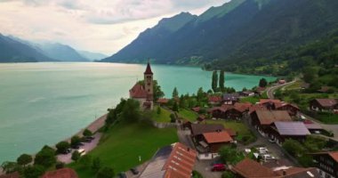 Alpler arasındaki gölün kıyısındaki geleneksel İsviçre evlerinin insansız hava aracı görüntüsü. Brienz, İsviçre. İsviçre 'nin Brienz şehrinin insansız hava aracı görüntüleri. Yazın İsviçre 'yi gezmek.