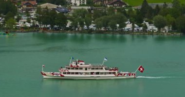 Alpler arasındaki gölün kıyısındaki geleneksel İsviçre evlerinin insansız hava aracı görüntüsü. Brienz, İsviçre. İsviçre 'nin Brienz şehrinin insansız hava aracı görüntüleri. Yazın İsviçre 'yi gezmek.