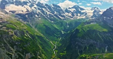 Yüksek dağların arasındaki kadim kar buzulu. Dağların zirveleri karla kaplıdır. İsviçre Alpleri 'nin dağlık arazisi. Drone dağdaki erimiş buzullara doğru yavaşça uçuyor..