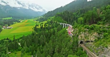 İsviçre 'de demiryolu manzaralı bir yol. İsviçre Alplerinde ekspres kırmızı İsviçre treni. Landwasser Viyadük Dünya mirası manzarası lüks Buzul ve Bernina ekspres yaz manzarası.