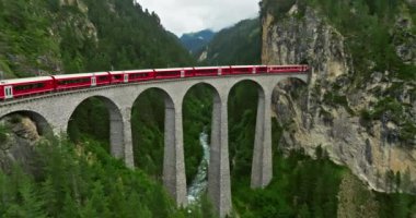 İsviçre 'de demiryolu manzaralı bir yol. İsviçre Alplerinde ekspres kırmızı İsviçre treni. Landwasser Viyadük Dünya mirası manzarası lüks Buzul ve Bernina ekspres yaz manzarası.