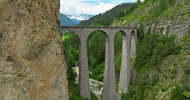 İsviçre 'de demiryolu manzaralı bir yol. İsviçre Alplerinde ekspres kırmızı İsviçre treni. Landwasser Viyadük Dünya mirası manzarası lüks Buzul ve Bernina ekspres yaz manzarası.