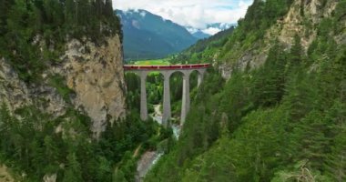İsviçre 'de demiryolu manzaralı bir yol. İsviçre Alplerinde ekspres kırmızı İsviçre treni. Landwasser Viyadük Dünya mirası manzarası lüks Buzul ve Bernina ekspres yaz manzarası.