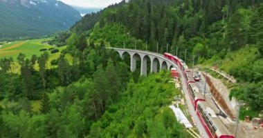 İsviçre 'de demiryolu manzaralı bir yol. İsviçre Alplerinde ekspres kırmızı İsviçre treni. Landwasser Viyadük Dünya mirası manzarası lüks Buzul ve Bernina ekspres yaz manzarası.
