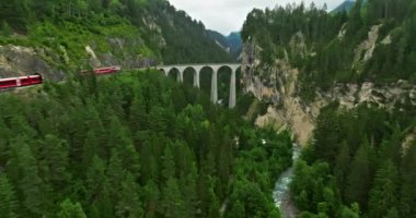 İsviçre 'de demiryolu manzaralı bir yol. İsviçre Alplerinde ekspres kırmızı İsviçre treni. Landwasser Viyadük Dünya mirası manzarası lüks Buzul ve Bernina ekspres yaz manzarası.