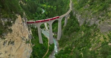 İsviçre 'de demiryolu manzaralı bir yol. İsviçre Alplerinde ekspres kırmızı İsviçre treni. Landwasser Viyadük Dünya mirası manzarası lüks Buzul ve Bernina ekspres yaz manzarası.