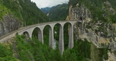 İsviçre 'de demiryolu manzaralı bir yol. İsviçre Alplerinde ekspres kırmızı İsviçre treni. Landwasser Viyadük Dünya mirası manzarası lüks Buzul ve Bernina ekspres yaz manzarası.