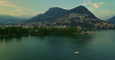 Lugano şehrinin havadan görünüşü ve San Salvatore dağından Lugano Gölü. İsviçre, Canton Ticino 'daki Lugano şehrine bakan Monte Bre' nin hava görüntüleri..