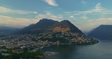 Lugano şehrinin havadan görünüşü ve San Salvatore dağından Lugano Gölü. İsviçre, Canton Ticino 'daki Lugano şehrine bakan Monte Bre' nin hava görüntüleri..
