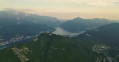 Lugano şehrinin havadan görünüşü ve San Salvatore dağından Lugano Gölü. İsviçre, Canton Ticino 'daki Lugano şehrine bakan Monte Bre' nin hava görüntüleri..