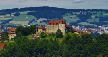 Yazın ortaçağ İsviçre kalesinin havadan görünüşü. İsviçre dağlarındaki yeşil bir vadide bir dron uçuyor. İsviçre 'deki ünlü Gruyere şatosu Schloss Greyerz olarak da bilinir..
