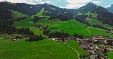 İsviçre geleneksel evleri olan yeşil Alp Vadisi. İsviçre 'nin merkezindeki otantik köy yukarıdan. Yazın güneşli bir günde, cennet gibi İsviçre köyünün havadan çekilmiş görüntüleri..