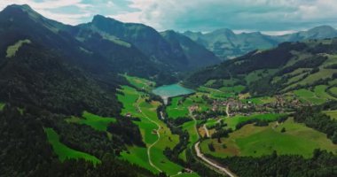 İsviçre geleneksel evleri olan yeşil Alp Vadisi. İsviçre 'nin merkezindeki otantik köy yukarıdan. Yazın güneşli bir günde, cennet gibi İsviçre köyünün havadan çekilmiş görüntüleri..