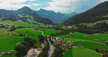 İsviçre geleneksel evleri olan yeşil Alp Vadisi. İsviçre 'nin merkezindeki otantik köy yukarıdan. Yazın güneşli bir günde, cennet gibi İsviçre köyünün havadan çekilmiş görüntüleri..