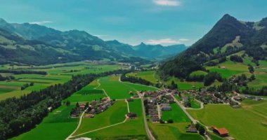 Yazın ortaçağ İsviçre kalesinin havadan görünüşü. İsviçre dağlarındaki yeşil bir vadide bir dron uçuyor. İsviçre 'deki ünlü Gruyere şatosu Schloss Greyerz olarak da bilinir..
