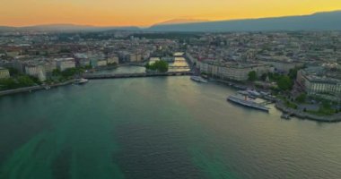 Cenevre, İsviçre 'de, Leman Gölü' nün güneybatısında yer alan bir şehirdir. Bir İHA gece şehrin üzerinde uçuyor. Köprülerin ve caddelerin üzerinden. İçi araba ve insan dolu..