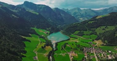 İsviçre geleneksel evleri olan yeşil Alp Vadisi. İsviçre 'nin merkezindeki otantik köy yukarıdan. Yazın güneşli bir günde, cennet gibi İsviçre köyünün havadan çekilmiş görüntüleri..