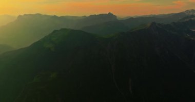 İnsansız hava aracı, arkasında dağlar olan yeşil renkli vadilerin üzerinden uçuyor. Yüksek Dağlar İsviçre 'nin ünlü simgeleridir. İsviçre 'deki Idyllic dağ manzarası, İsviçre kırsal havası.