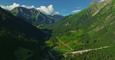İnsansız hava aracı, arkasında dağlar olan yeşil renkli vadilerin üzerinden uçuyor. Yüksek Dağlar İsviçre 'nin ünlü simgeleridir. İsviçre 'deki Idyllic dağ manzarası, İsviçre kırsal havası.