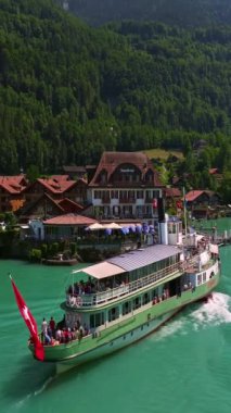 İsviçre 'de su taşımacılığı. İsviçre Gölü 'nde yol alıyorum. Interlaken Gölü 'ndeki hava manzaralı vapur gemisi. İsviçre yaz turizmi merkezi. Turkuaz mavi su. Yolcu gemisinde İsviçre bayrağı.